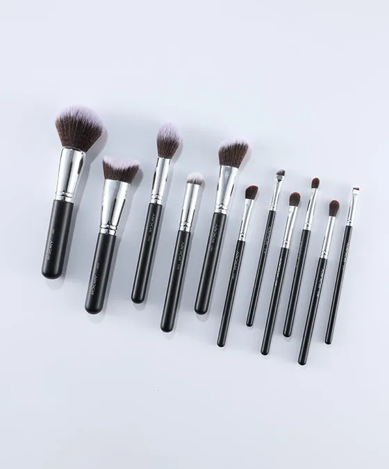 Flat lay of V101 12-piece makeup brush set with fluffy powder, angled foundation, eye, and detail brushes on white background.
