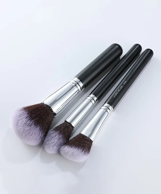 Closeup of large fluffy synthetic hair powder brush from V101 set, showcasing soft bristles and premium black handle design.