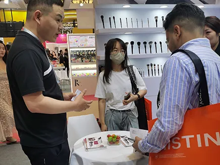 “AINOCHI Factory team at the 2025 China Beauty Expo in Shanghai, presenting professional makeup brushes to visitors.”