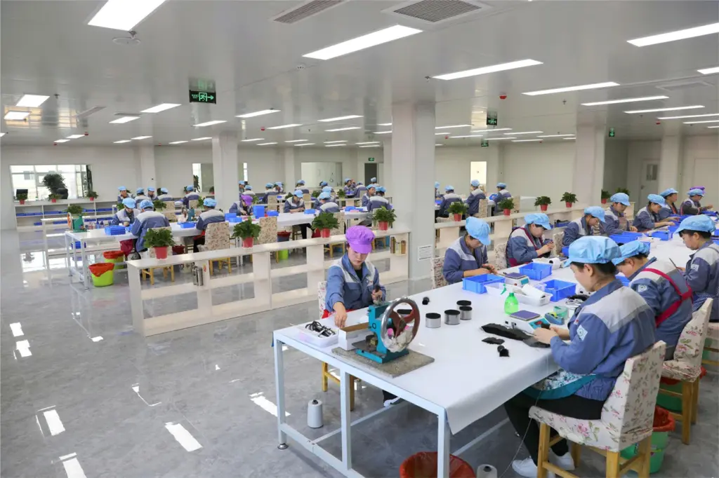 Efficient workshop for quality manufacturing, showing workers assembling makeup brushes in a clean modern factory environment.