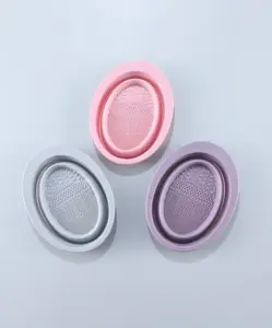 Assorted silicone makeup brush cleaning pads in pink, grey, and purple, each with textured ridges for deep, effective brush cleaning.