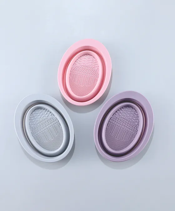 Assorted silicone makeup brush cleaning pads in pink, grey, and purple, each with textured ridges for deep, effective brush cleaning.