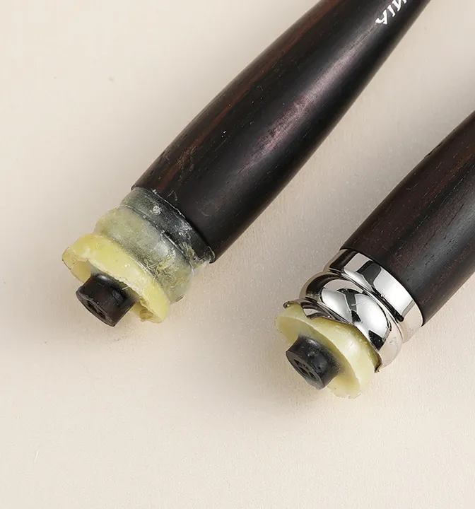 Bottom view of makeup brush handles showing reverse glue injection process for stronger, safer connection.