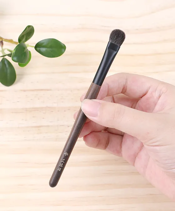 Y-s109 eyeshadow brush held in hand to show handle length and size