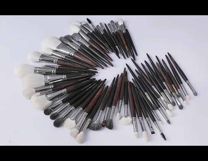 Large collection of AINOCHI makeup brushes arranged on a white background, showing the factory’s capacity and variety of brush designs.