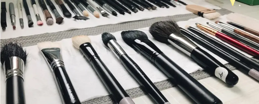 Clean makeup brushes laid flat on towels to air dry after washing, showing how to dry makeup brushes properly in a neat, professional setup.