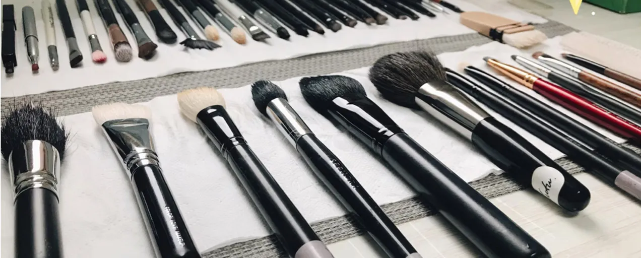 Clean makeup brushes laid flat on towels to air dry after washing, showing how to dry makeup brushes properly in a neat, professional setup.