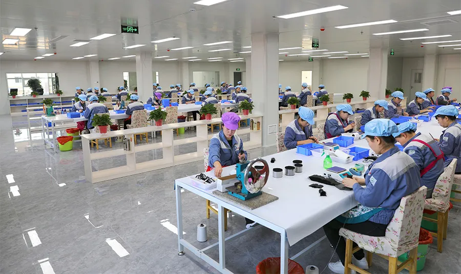 Dust‑free makeup brush factory production workshop with workers assembling brushes at long tables